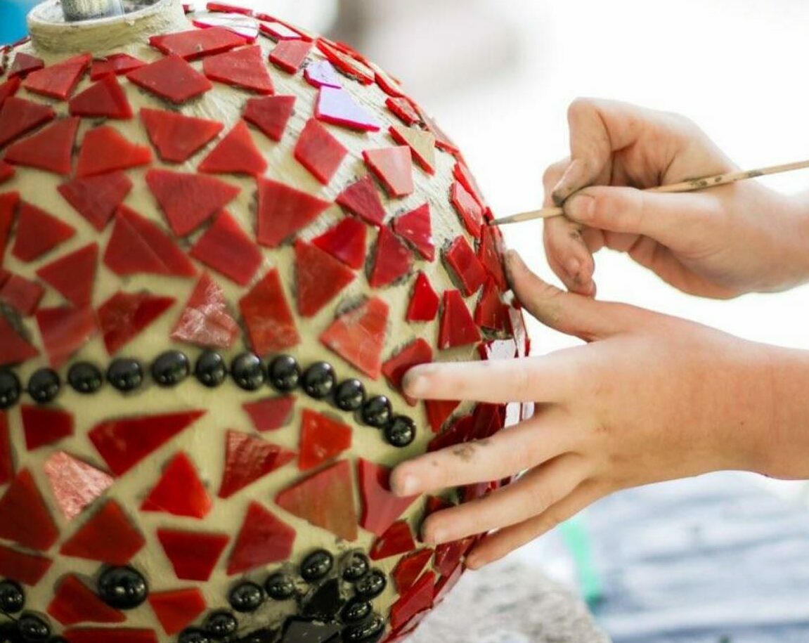 SPARK! Mosaic hands applying mosaic tiles